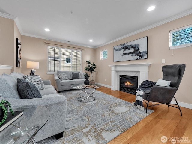 living room featuring hardwood / wood-style floors, crown molding, and a healthy amount of sunlight