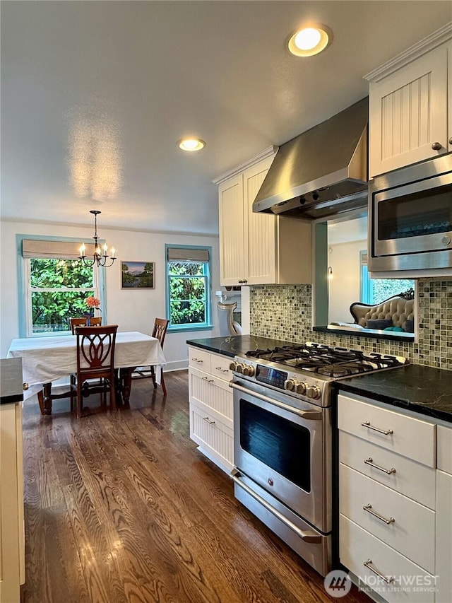 kitchen with appliances with stainless steel finishes, white cabinets, dark hardwood / wood-style flooring, and ventilation hood