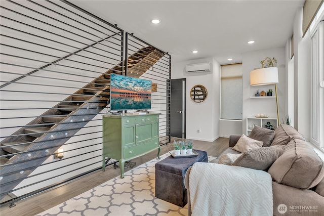 living room featuring recessed lighting, baseboards, wood finished floors, and a wall mounted air conditioner