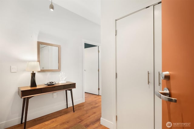 hall featuring baseboards and light wood-style floors