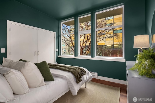 bedroom featuring a closet, baseboards, and wood finished floors