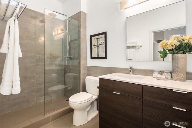 bathroom featuring a stall shower, vanity, toilet, and tile patterned floors