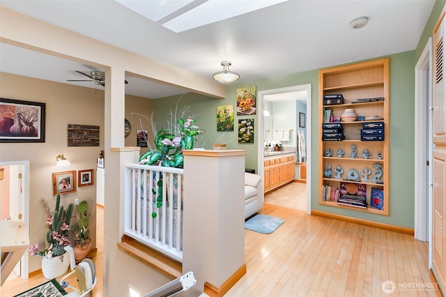 hall featuring light hardwood / wood-style floors and a skylight