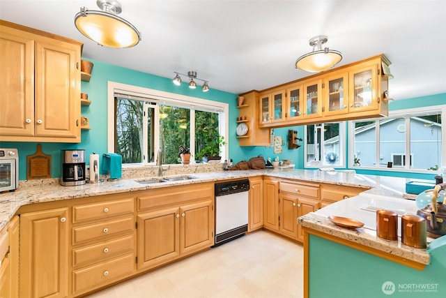 kitchen with sink, light brown cabinetry, and light stone countertops