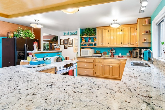 kitchen featuring stainless steel range with electric stovetop, sink, black fridge, and light stone counters