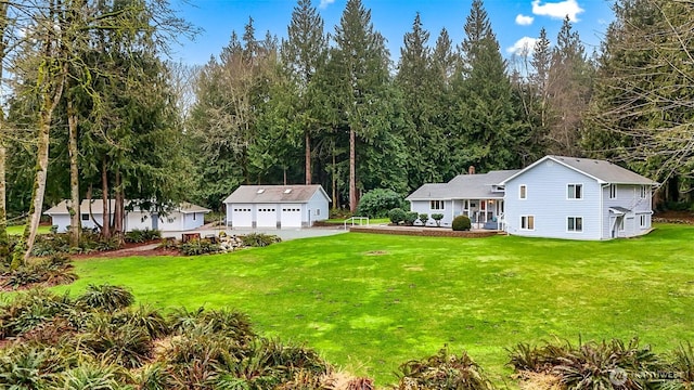 view of yard with a garage, an outdoor structure, and a porch