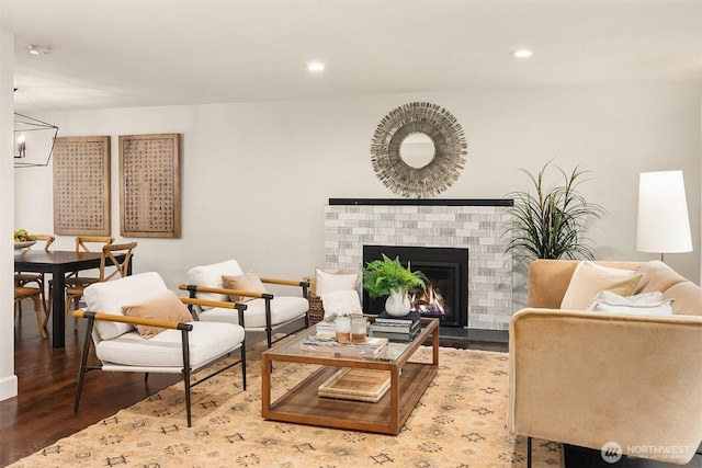 living area featuring recessed lighting, a brick fireplace, and wood finished floors