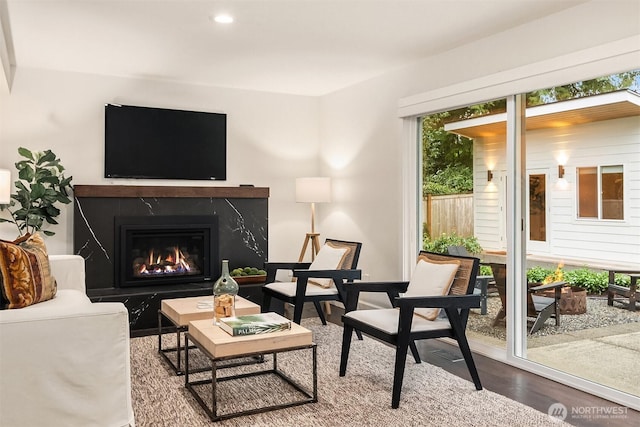 living room with a premium fireplace, wood finished floors, and recessed lighting