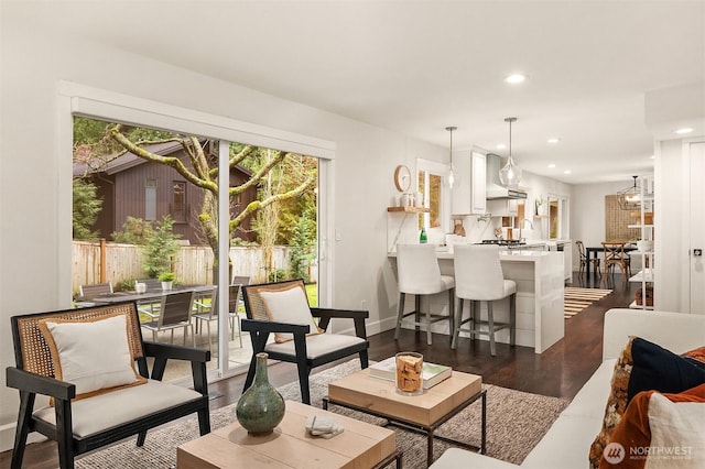 living room featuring baseboards, dark wood-style flooring, recessed lighting, and a healthy amount of sunlight