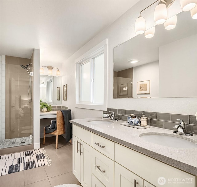 full bathroom featuring double vanity, a stall shower, a sink, and tile patterned floors