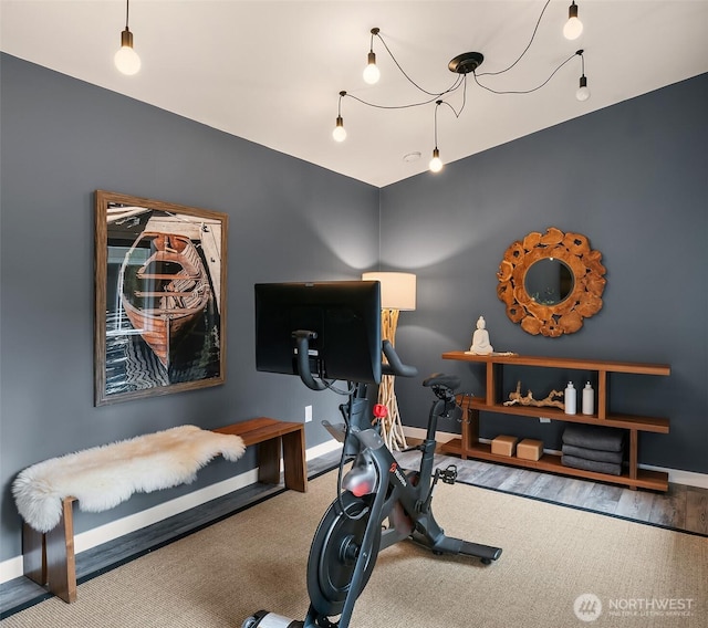 workout area featuring carpet and baseboards