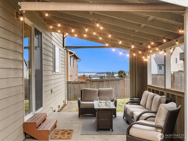 patio terrace at dusk with an outdoor living space with a fire pit