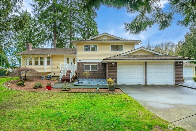 tri-level home featuring an attached garage, brick siding, concrete driveway, a chimney, and a front yard