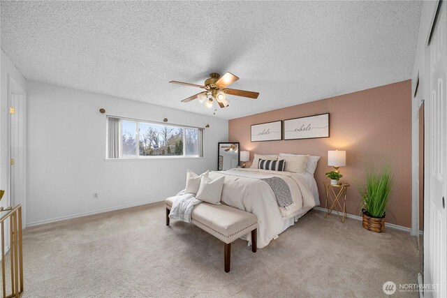 bedroom with light colored carpet, ceiling fan, a textured ceiling, and baseboards