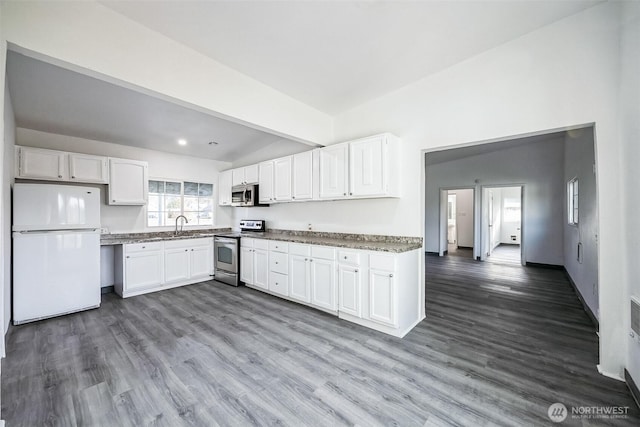 kitchen featuring appliances with stainless steel finishes, white cabinets, and hardwood / wood-style floors