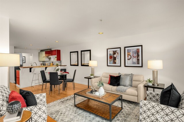 living area featuring light wood-style floors, recessed lighting, and baseboards