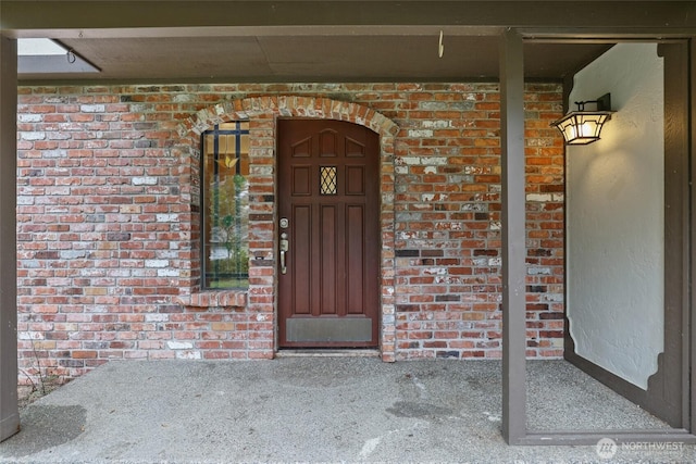 view of exterior entry featuring brick siding