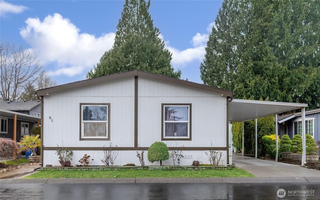 view of side of home with driveway and a carport