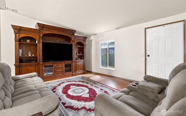 living area with baseboards and wood finished floors