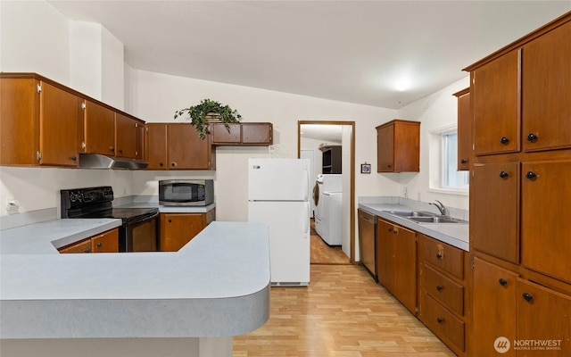 kitchen featuring under cabinet range hood, stainless steel appliances, a sink, light countertops, and brown cabinets