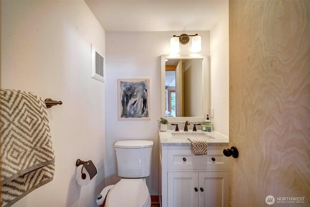 bathroom featuring toilet, visible vents, and vanity