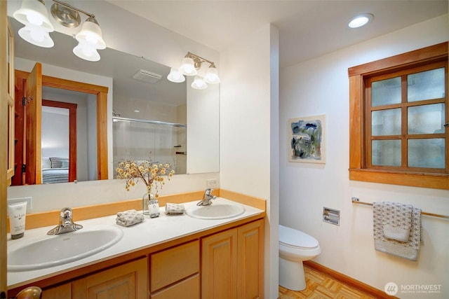 full bathroom featuring toilet, visible vents, a sink, and a shower with shower door