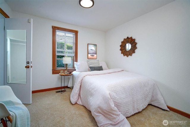 bedroom featuring light carpet and baseboards