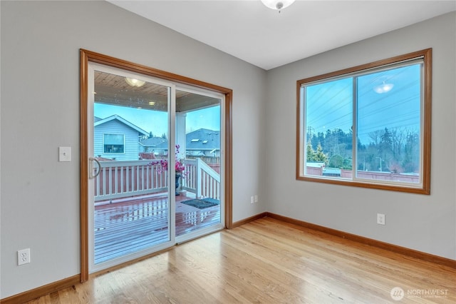 spare room with light wood-type flooring and baseboards