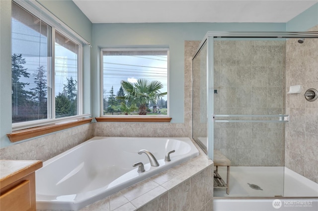 full bathroom featuring a garden tub, a shower stall, and vanity