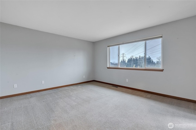 carpeted empty room with baseboards and visible vents