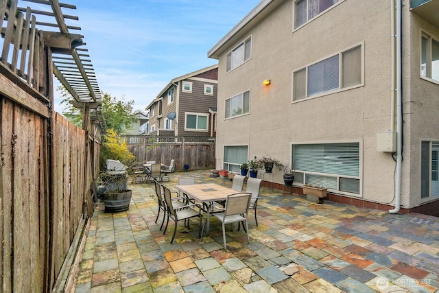 view of patio featuring outdoor dining area, a fenced backyard, and a pergola