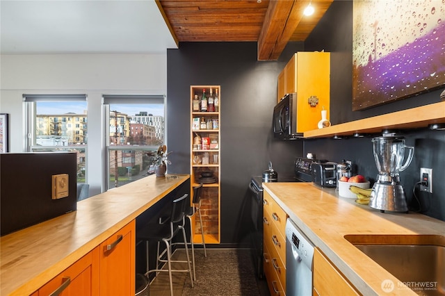 kitchen featuring black microwave, butcher block countertops, beamed ceiling, and stainless steel dishwasher