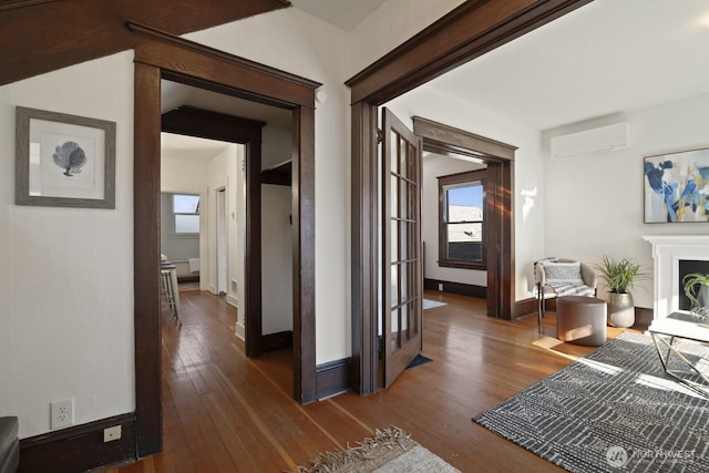 corridor featuring dark hardwood / wood-style flooring and a wall unit AC