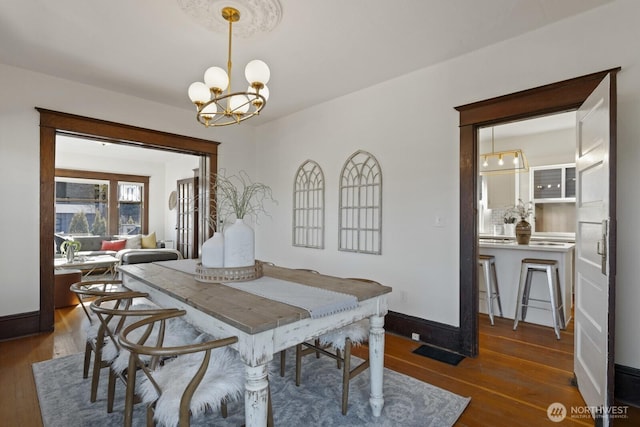 dining room featuring a notable chandelier and dark hardwood / wood-style floors