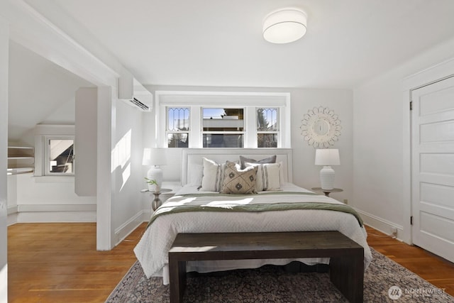 bedroom featuring an AC wall unit and wood-type flooring