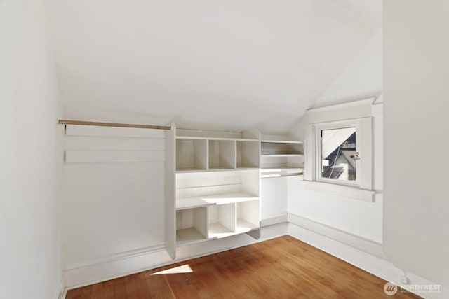 walk in closet with hardwood / wood-style flooring and lofted ceiling