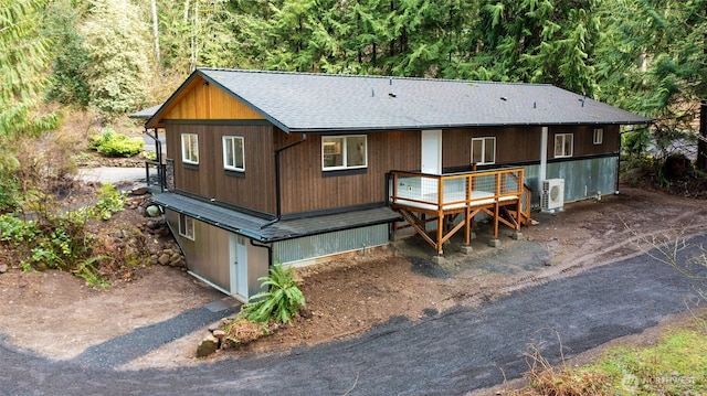 rear view of property with ac unit and a wooden deck