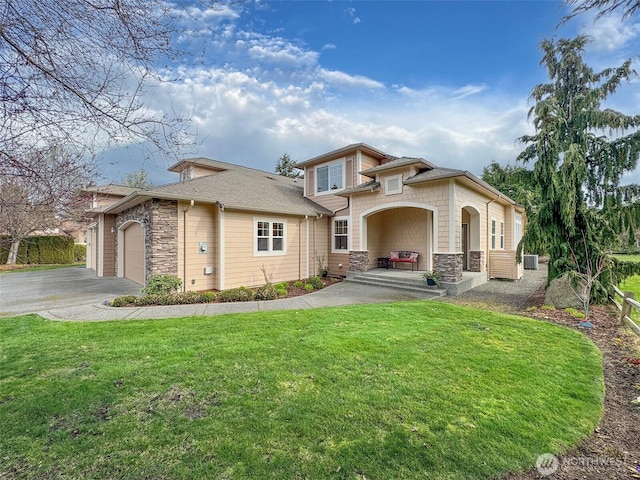 view of front of property with aphalt driveway, stone siding, a front lawn, and an attached garage