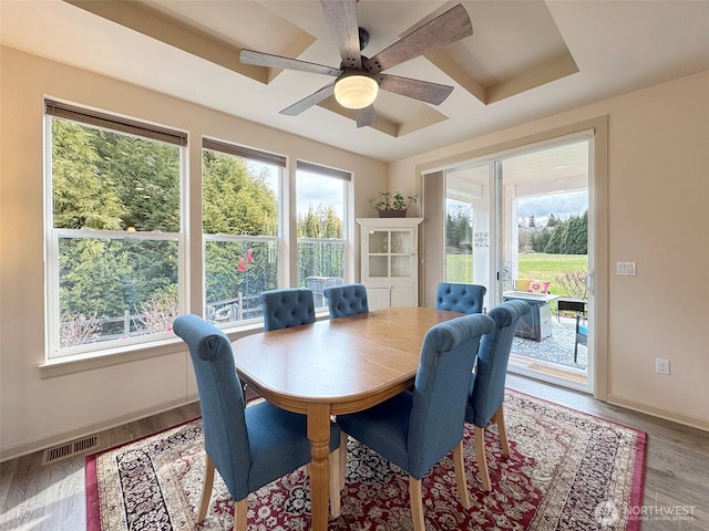 dining room with visible vents, a ceiling fan, coffered ceiling, wood finished floors, and baseboards