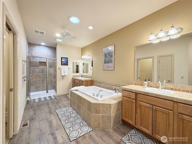 full bathroom with wood finished floors, visible vents, a stall shower, a sink, and a bath