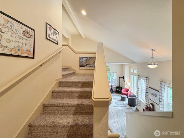 stairway featuring vaulted ceiling with beams, baseboards, and wood finished floors