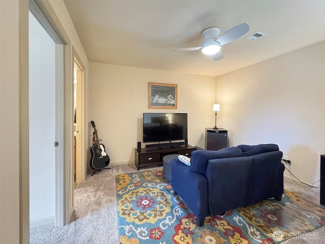 living area featuring visible vents, baseboards, a ceiling fan, and carpet flooring