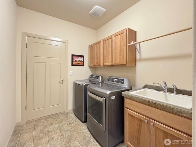 washroom with baseboards, light tile patterned floors, washer and dryer, cabinet space, and a sink