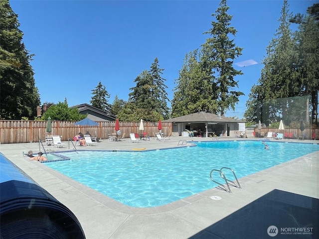 community pool featuring a patio area and fence