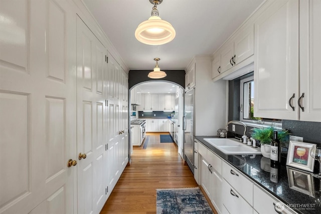 4801 Hyada Blvd NE, Tacoma, WA 98422 - kitchen featuring white cabinetry, built in refrigerator, a sink, and light wood-type flooring