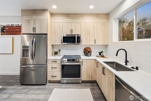 kitchen featuring appliances with stainless steel finishes, sink, tasteful backsplash, and light brown cabinets