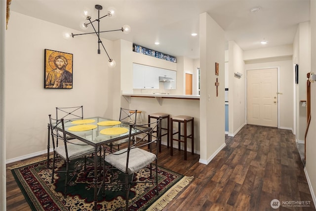 dining area featuring dark wood-style floors, recessed lighting, baseboards, and an inviting chandelier