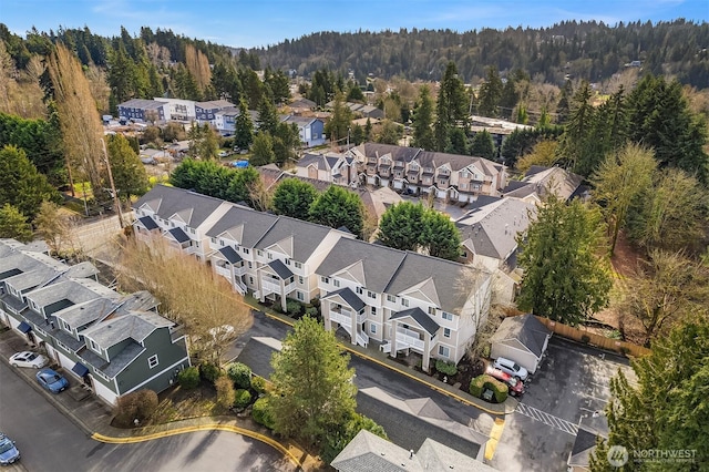 drone / aerial view featuring a residential view and a wooded view