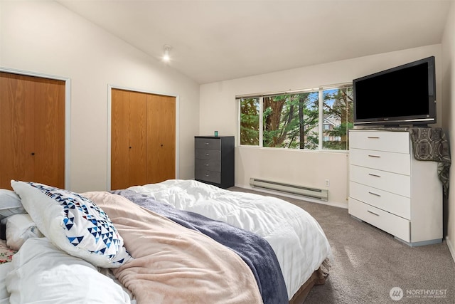 bedroom with lofted ceiling, baseboard heating, multiple closets, and light colored carpet