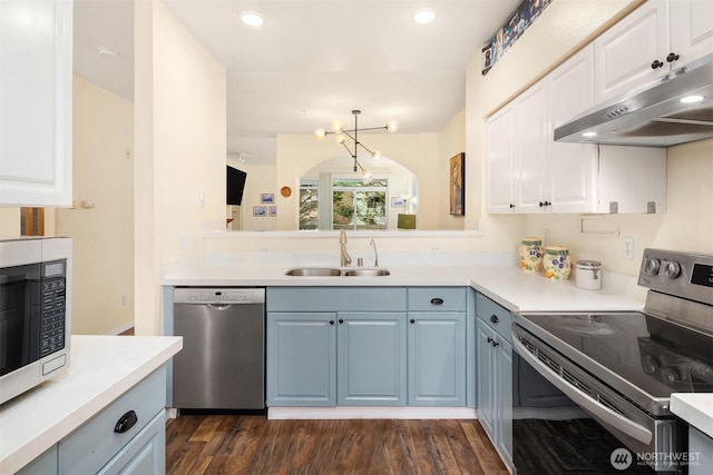 kitchen featuring appliances with stainless steel finishes, light countertops, a sink, and under cabinet range hood